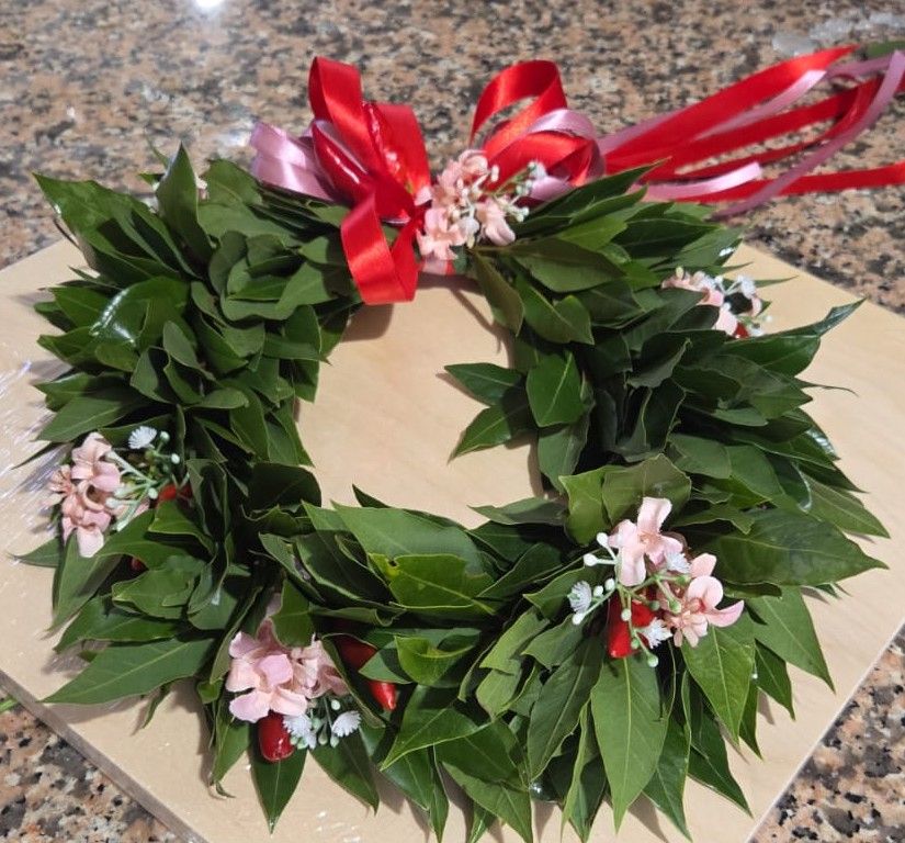 Corona d'alloro per laurea con fiocco di nastri rossi e rosa, fiorellini rosa e peperoncini rossi